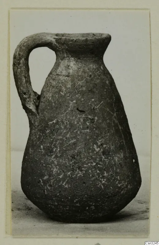 Small jug with a single strap handle, Pottery Plain White IV-V, photographed on a plain background.
