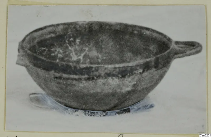 Pottery White Painted VI bowl with a side handle and a small lug, shown on a pale base