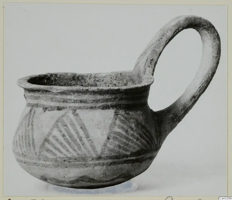 White Painted III-2 cup from Lapithos with a tall loop handle and hatched triangles on the body