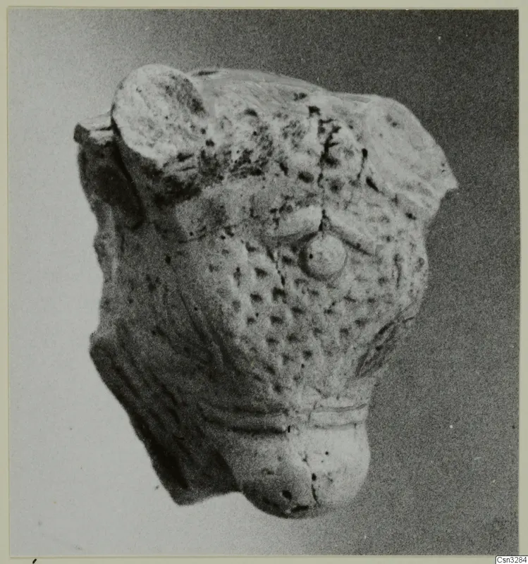 Terracotta minor plastic fragment with a pitted surface and a round knob, photographed against a grey background