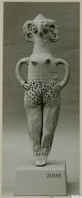 Terracotta idol figurine of a standing female figure with arms on hips and a dotted pattern on the lower body