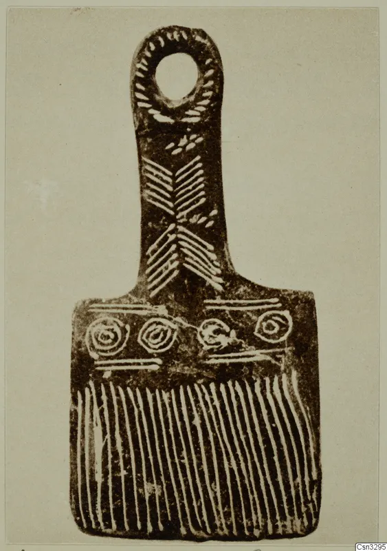 Flat terracotta idol from Vonous with a loop at the top, chevron and spiral patterns, and comb-like lines along the base