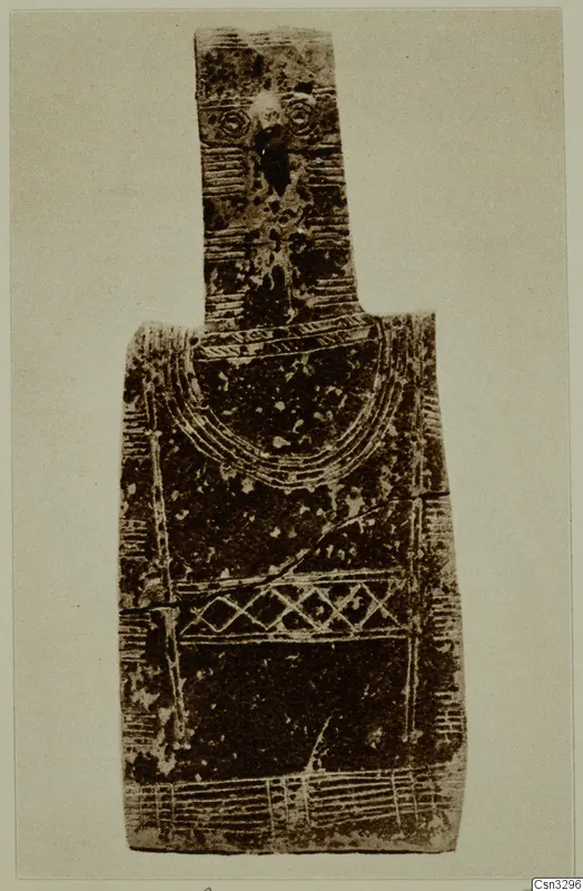 Flat figure-shaped terracotta idol with a narrow upper part and incised arcs, lattice and bands on the body