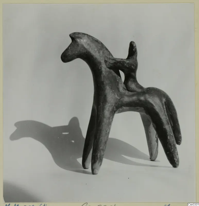 Terracotta figurine of a four-legged animal with a long neck and a small upright stub on its back, shown against a pale background