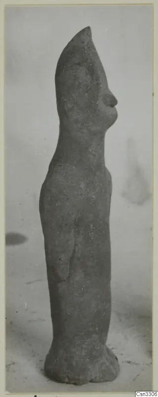 Terracotta figurine of a standing figure, seen in side profile against a plain backdrop