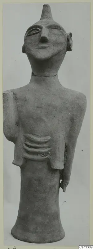 Terracotta figurine of a standing human figure with a conical head-top, a long neck and a pronounced nose.
