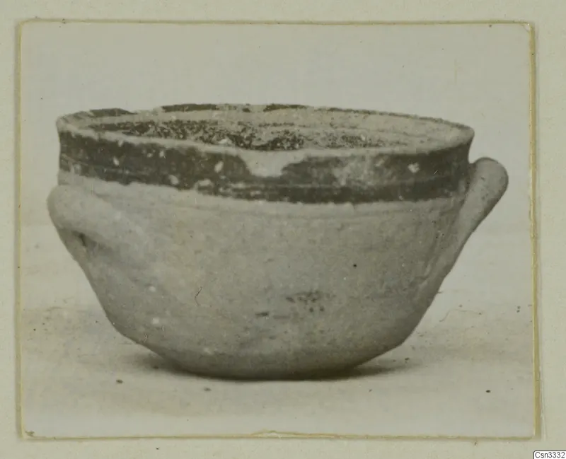 Small bowl with two side handles and a dark painted band around the upper body and rim.