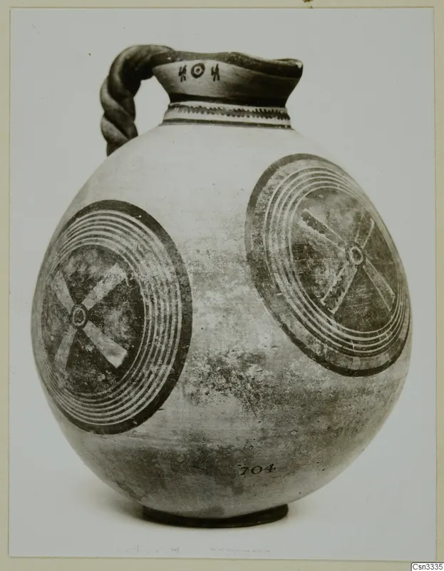 White Painted IV vessel with a twisted strap handle and two large concentric circle motifs on its body