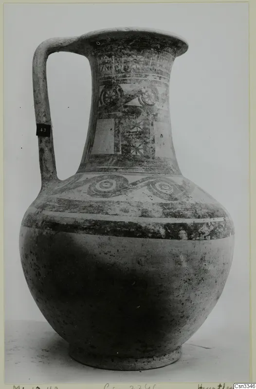 Painted pottery jug with a single loop handle, from Milia, on a pale surface against a grey backdrop