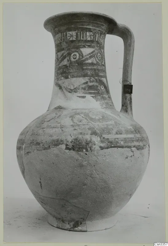 Painted jug with a strap handle and bands of decoration on the neck and shoulder