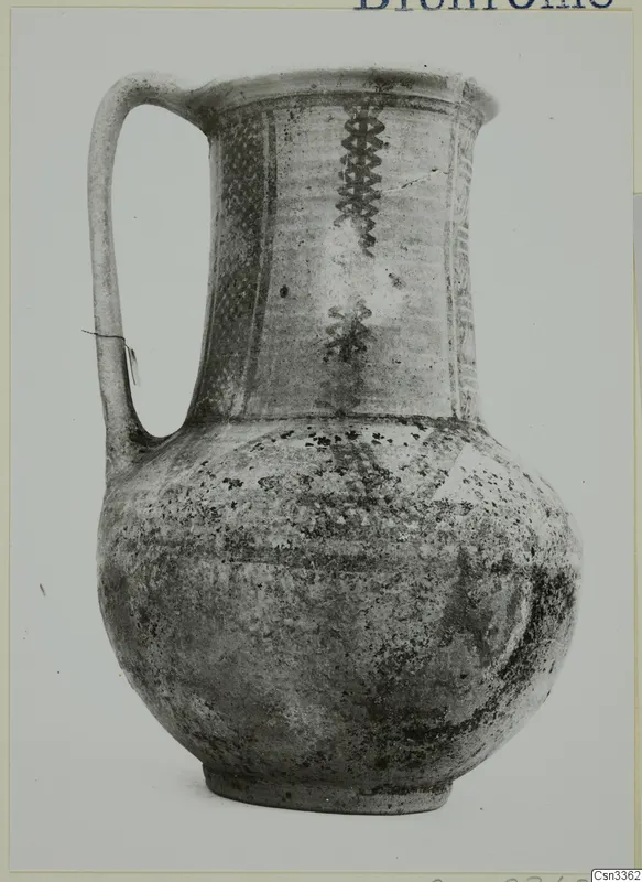 Wheel-made painted jug with a strap handle and banded decoration on the neck and shoulder