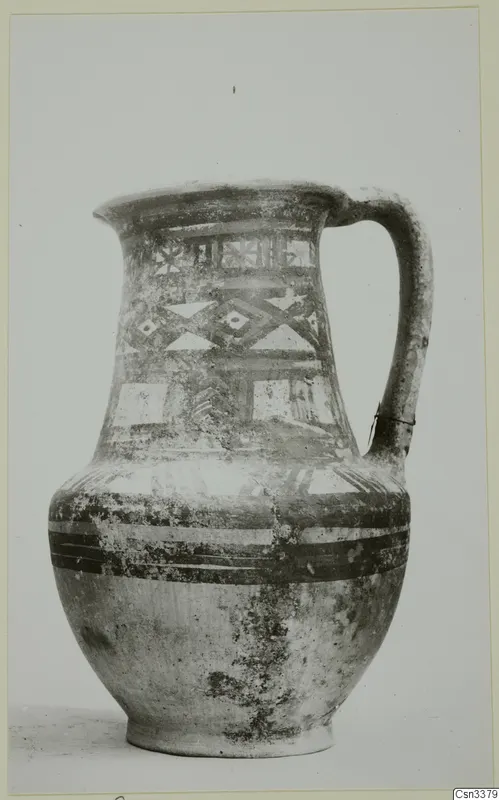 Wheel-made bichrome jug with a single handle and painted geometric bands