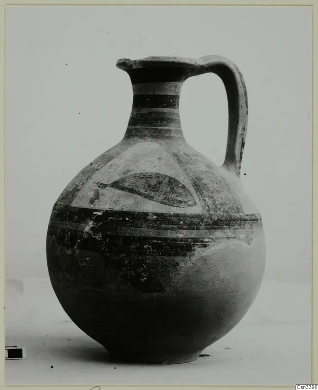 Bichrome wheel-made jug with a single handle, banded neck and a dark curved motif in a panel on the shoulder