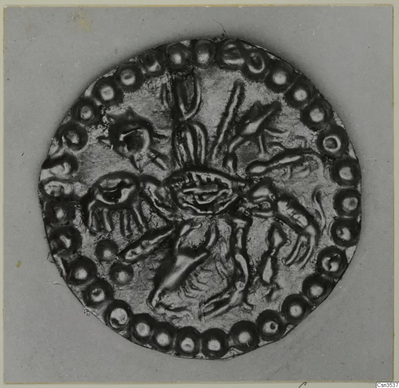 Round gold disc ornament with a raised central motif and a ring of bead-like rosettes around its edge.