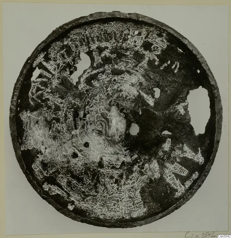 Circular metal bowl seen from above, its dark surface covered with incised figures, animals and patterns