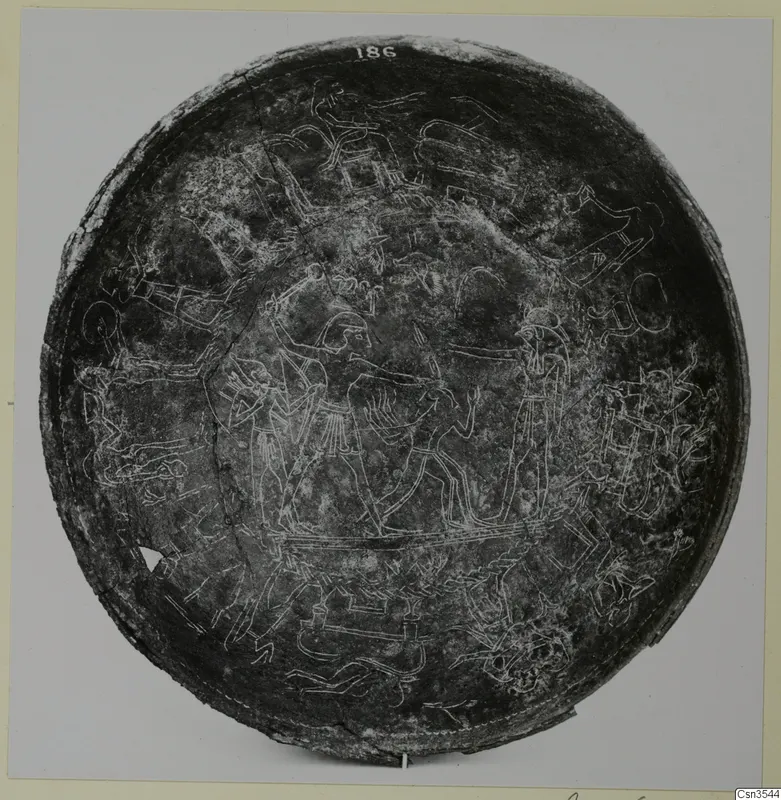 Circular bowl with engraved scenes of figures, animals and chariot-like shapes, photographed from above