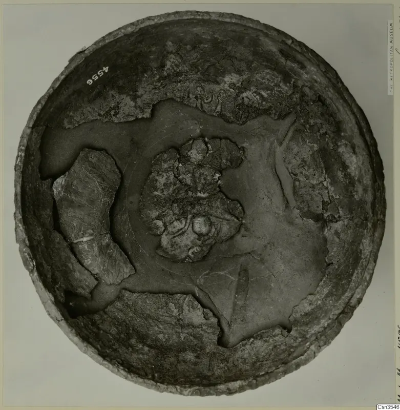Round decorated bowl seen from above, its interior showing worn painted patterns and a central cluster of fragments