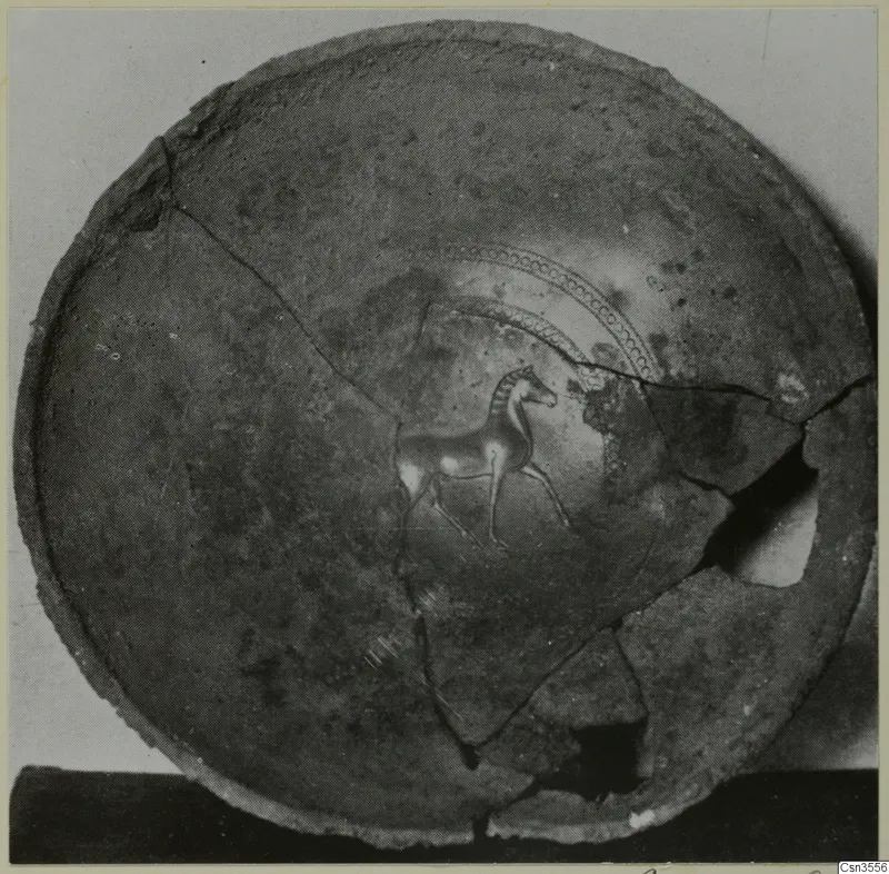 Interior of a broken and mended round bowl with a small painted animal figure and dotted concentric arcs.