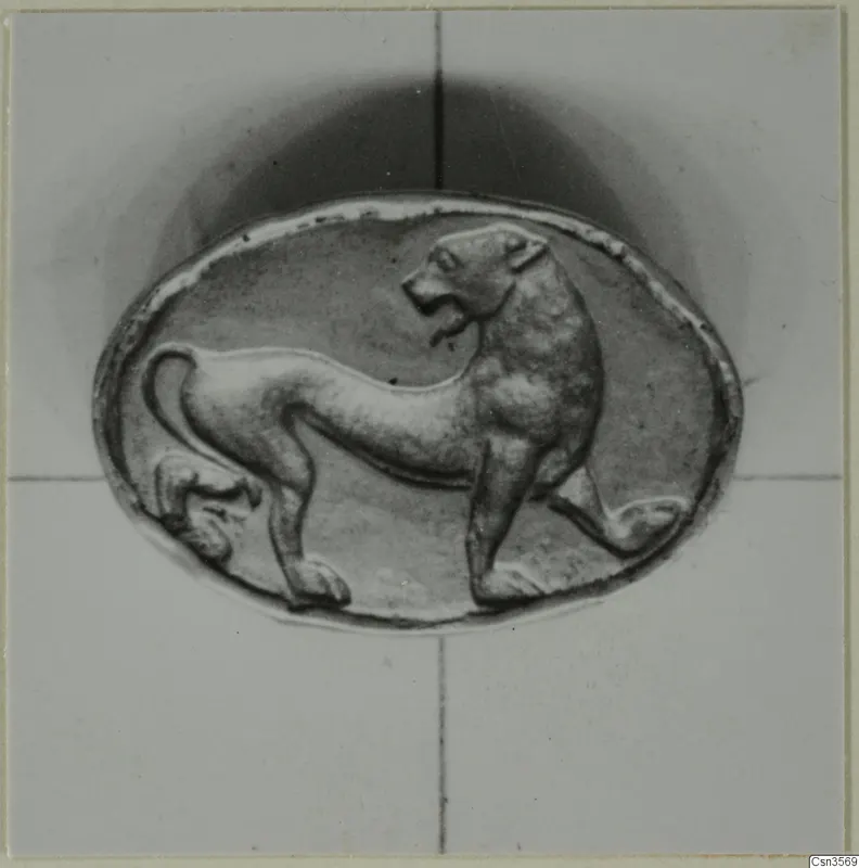 Oval object with a raised relief of an animal standing in profile, facing right