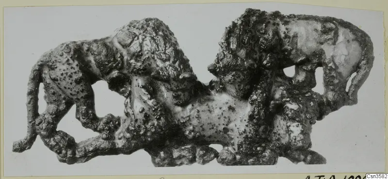 Bronze sculpture of two lions attacking a bull, with a heavily corroded surface