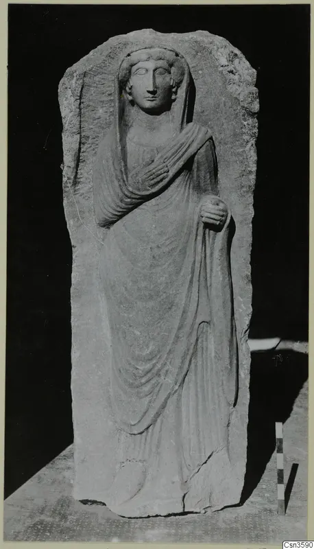 Limestone relief of a standing veiled woman in an arched slab, shown with a scale rod beside it