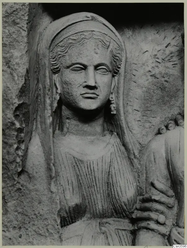 Carved stone relief of a woman's head and upper body, with wavy hair under a veil and a visible earring