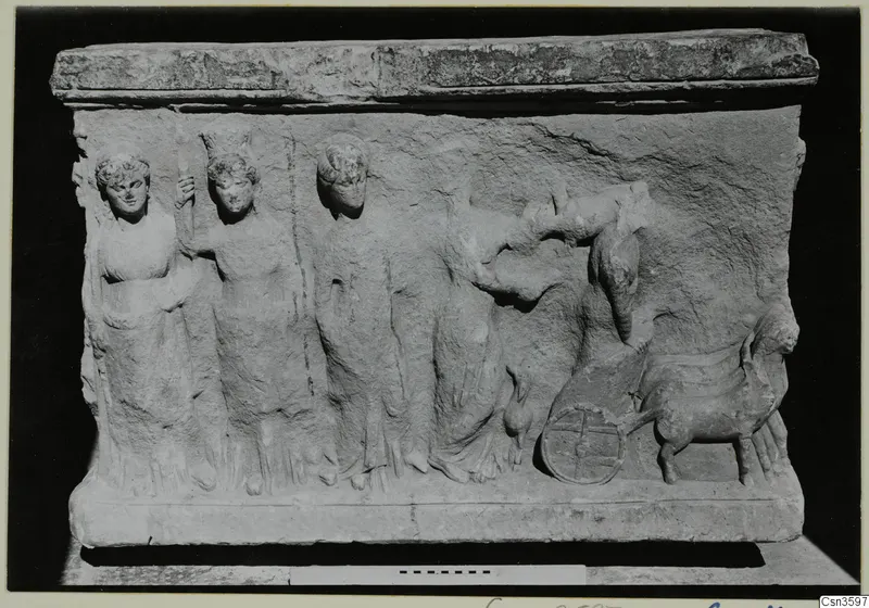 Stone relief block with four standing figures at left, a wheel and an animal at right