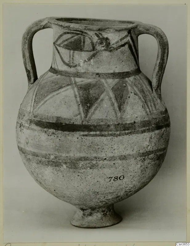Painted two-handled jar with a footed base and black bands and linear motifs on a pale surface