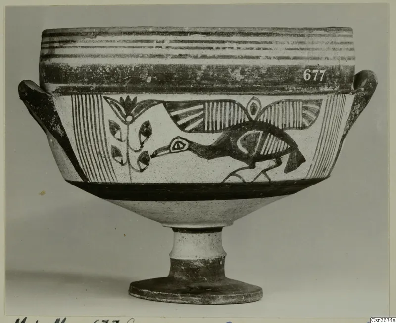 Painted pottery vessel on a high foot, with a dark bird and plant motif between bands, photographed against a grey backdrop