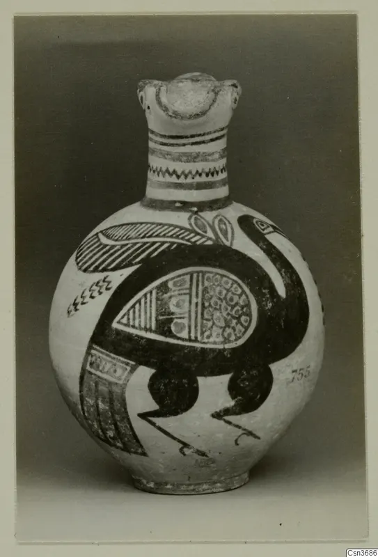 Painted jug with a modelled head at the top of the neck and a large dark bird painted on the body