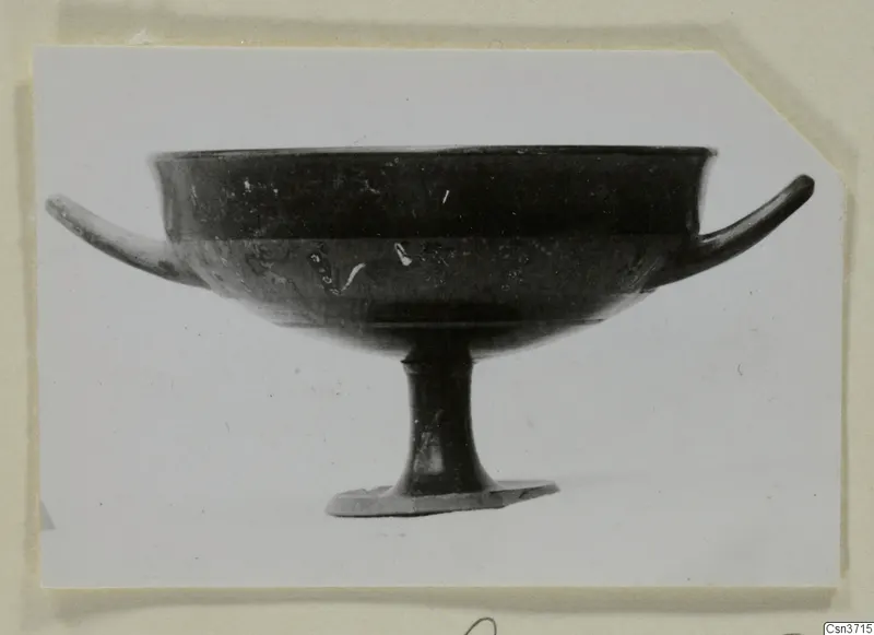 Footed bowl with two thin horizontal handles and a dark surface, photographed in side view against a white background.