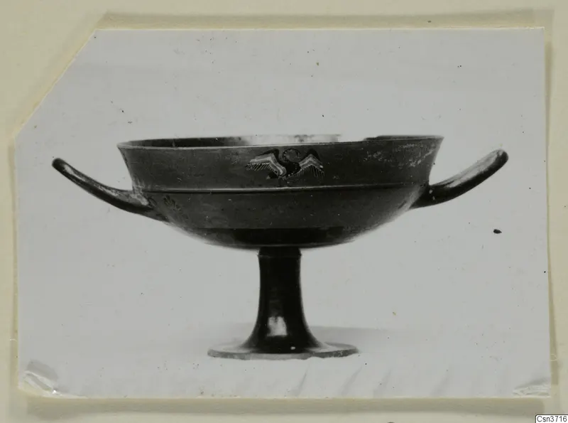 Stemmed bowl with two horizontal handles and a small painted bird-like figure with spread wings on its side.