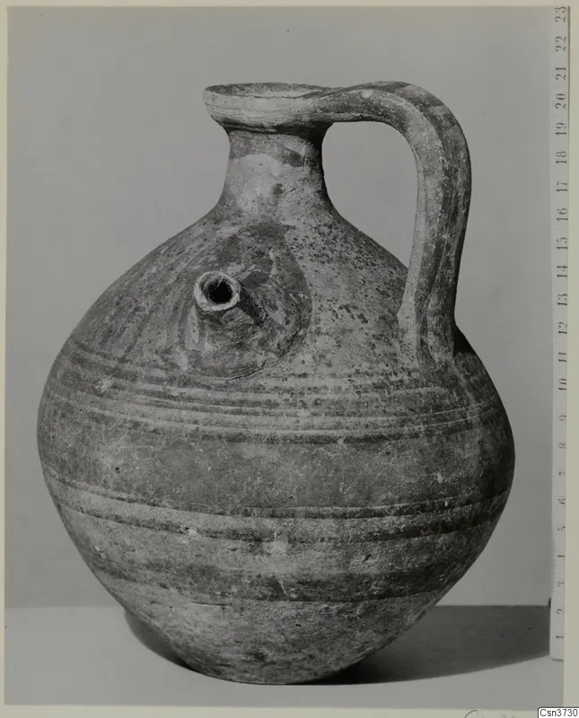 Pottery Bichrome V: a globular jug with a strap handle and a small tubular spout, shown with a scale ruler