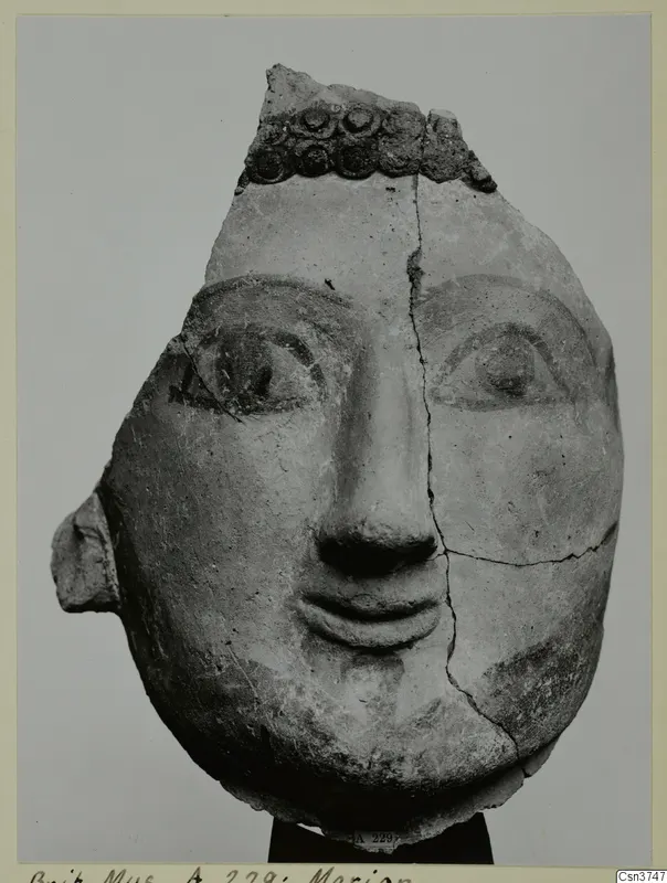 Terracotta head with painted eyes and brows, from Mersinaki, with a band of circular ornament across the top.