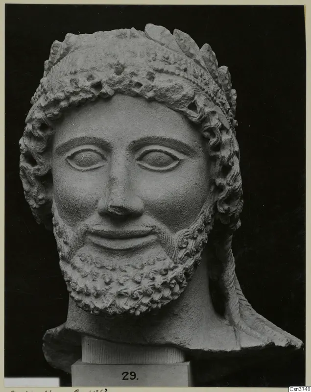 Cypro-Greek II limestone head of a bearded man from Arsos, shown on a plinth against a black background