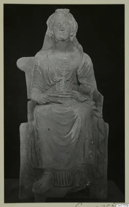 Seated female figurine on a chair with curved arms, shown against a black background