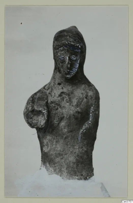 Terracotta figurine of a bust with a head covering and traces of blue and white paint