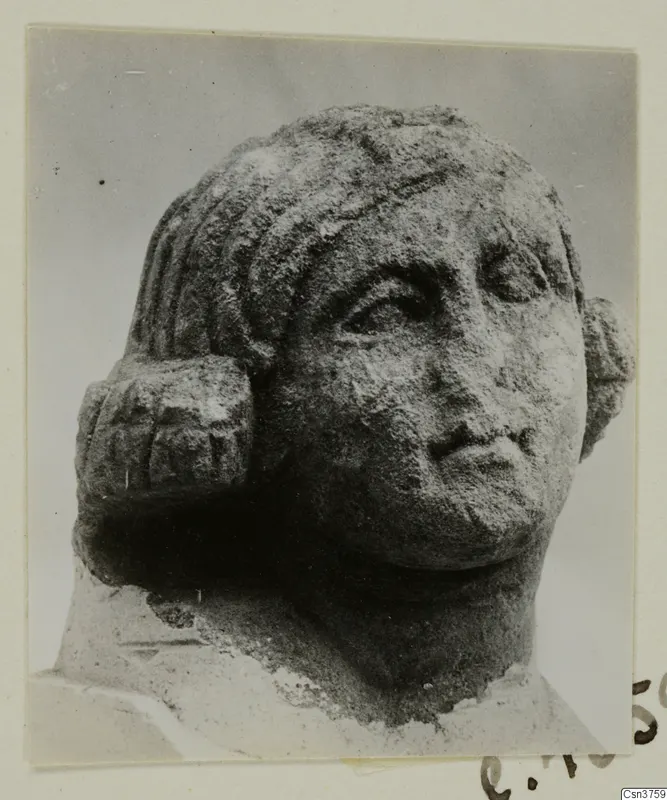 Stone statue head from Arsos, shown in three-quarter view with wavy hair and a weathered surface