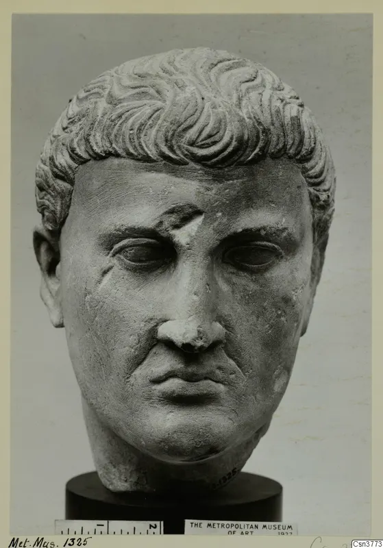 Roman stone head of a man with short, wavy hair, shown on a dark cylindrical base