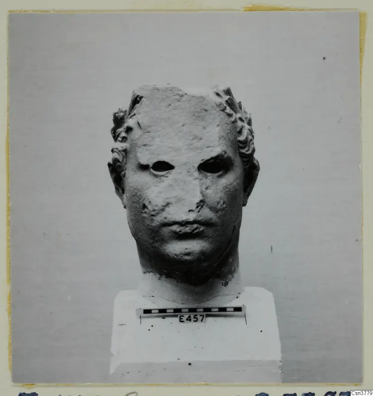 Roman sculpture: stone head on a white plinth, front view, with a scale bar and number label
