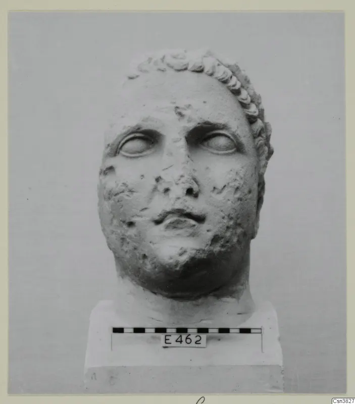 Head of a statue in stone, shown frontally on a base with a scale bar.