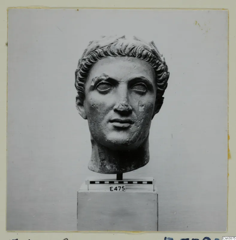 Hellenistic and Roman sculpture: carved stone head with curled hair, shown on a stand with a scale bar and label E475