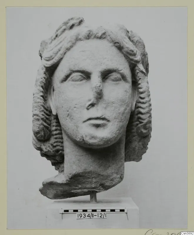 Marble head of a young woman with wavy hair swept back, shown on a stand with a scale bar.