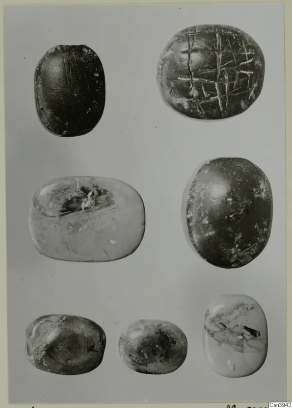 Seven oval seals and gems in three rows, one with an incised cross-hatched pattern on its flat face