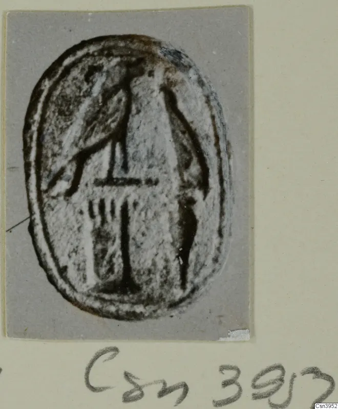 Oval seal or gem with an incised linear design, photographed on a grey card