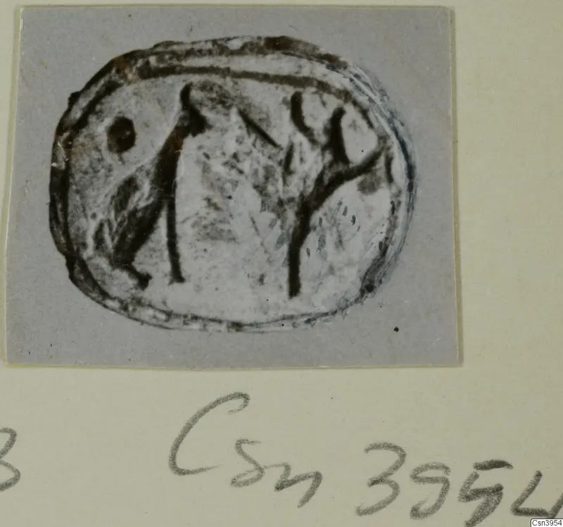 Oval seal or gem with an engraved design of dark lines, photographed on a grey card mount