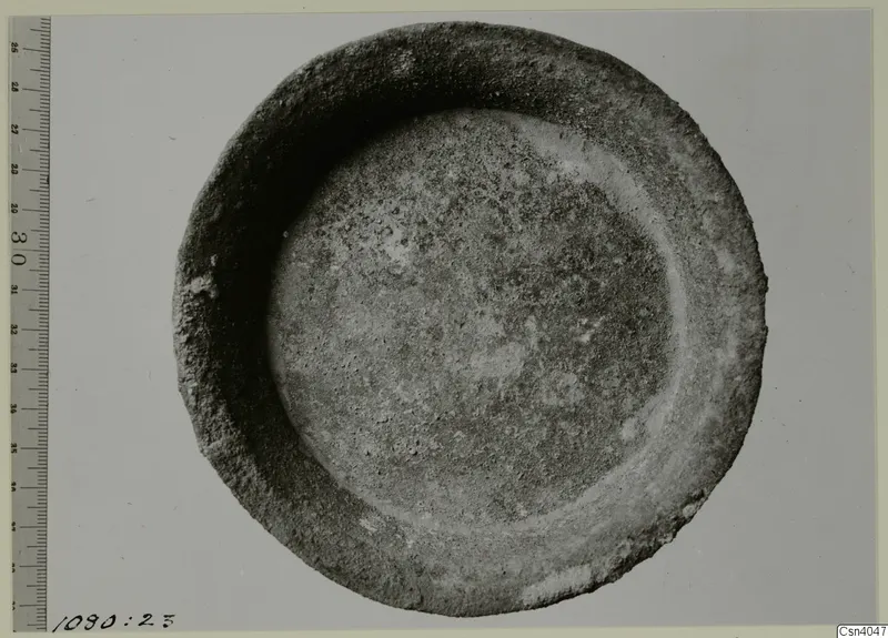 Shallow bowl with a thick rim, photographed from above beside a ruler for scale