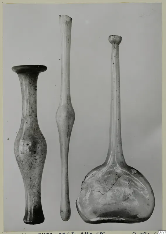 Three blown glass vessels of differing forms, standing side by side.