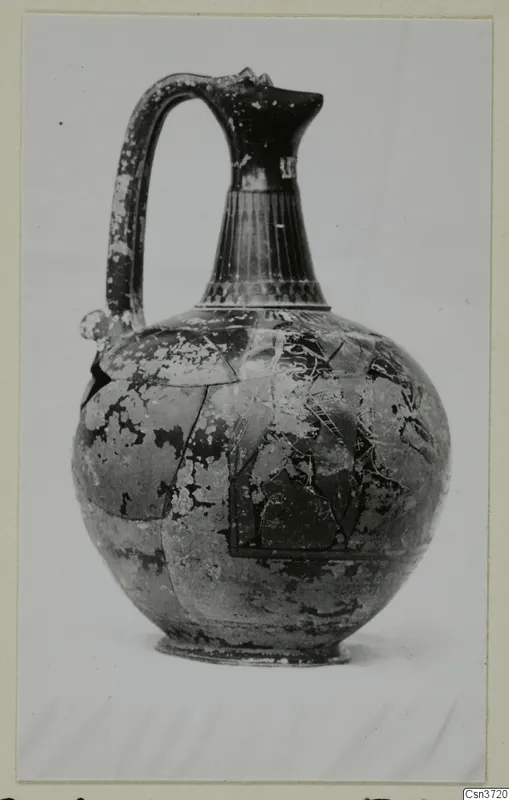 Globular jug with a tall fluted neck and strap handle, shown against a pale background