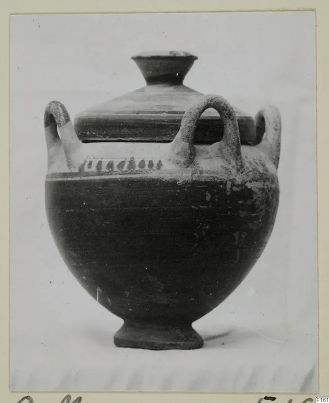 Lidded pottery vessel with a footed base and loop handles, shown on a mounted photograph card.